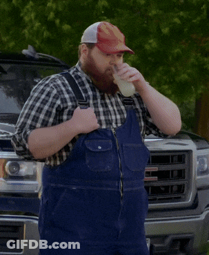 A Man Wearing Overalls And A Hat That Says ' Gmc ' On It Drinks From A Cup GIF