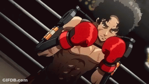 A Man Wearing Red Boxing Gloves Is Standing In A Boxing Ring GIF