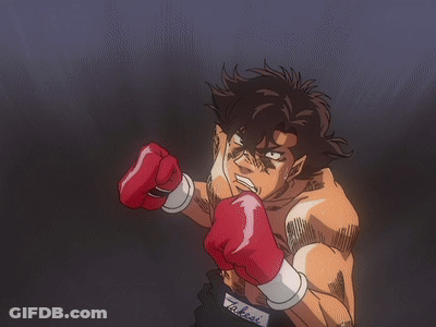 A Man Wearing Red Boxing Gloves Throws A Punch In A Dark Room GIF