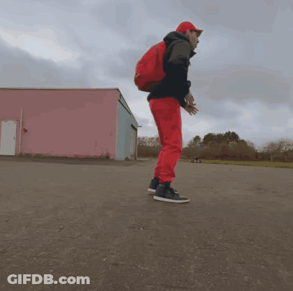 A Man Wearing Red Pants And A Red Backpack Is Jumping In The Air GIF
