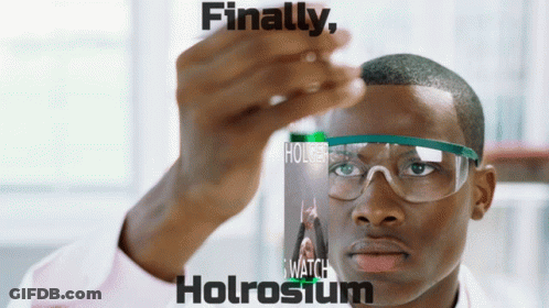 A Man Wearing Safety Goggles Holds A Bottle Of Holrosium GIF