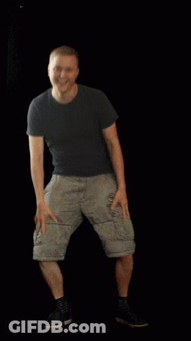A Man Wearing Shorts And A Black Shirt Is Standing With His Hands On His Hips GIF