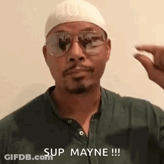 A Man Wearing Sunglasses , A Hat And A Green Shirt Is Holding A Pill In His Hand . GIF