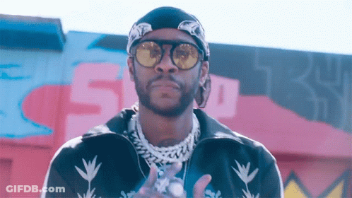 A Man Wearing Sunglasses And A Bandana Is Standing In Front Of A Wall With The Number 5 On It GIF