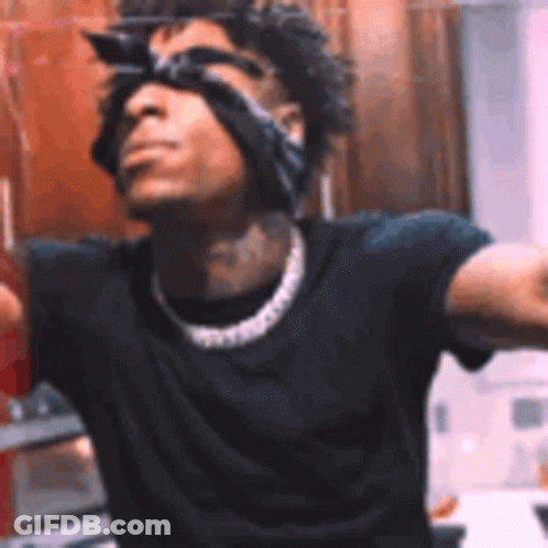 A Man Wearing Sunglasses And A Bandana On His Head Is Standing In Front Of A Mirror . GIF