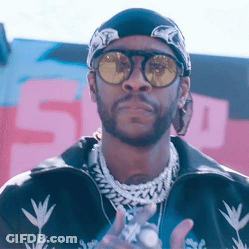 A Man Wearing Sunglasses And A Bandana Stands In Front Of A Sign That Says 5 GIF