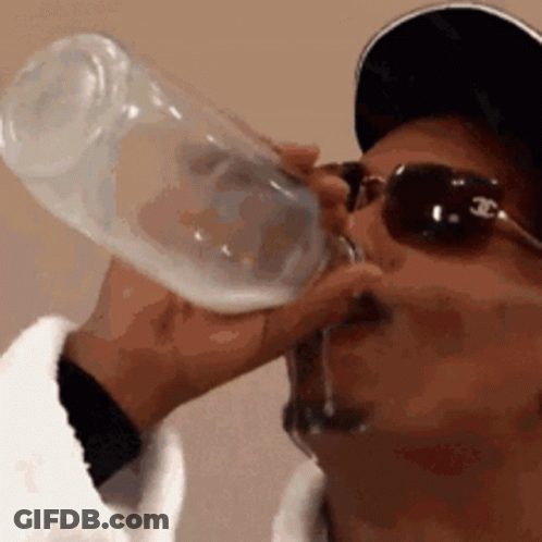 A Man Wearing Sunglasses And A Baseball Cap Is Drinking From A Bottle . GIF