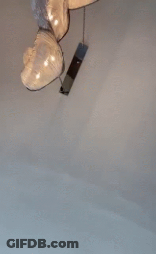A Man Wearing Sunglasses And A Baseball Cap Is Standing In A Room . GIF