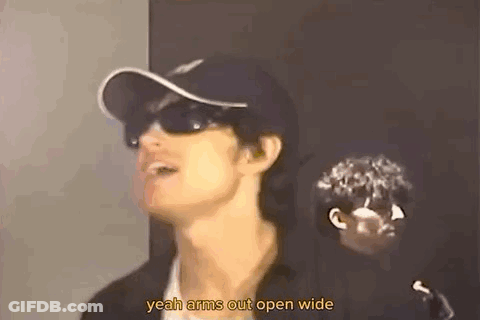 A Man Wearing Sunglasses And A Baseball Cap Is Talking . GIF