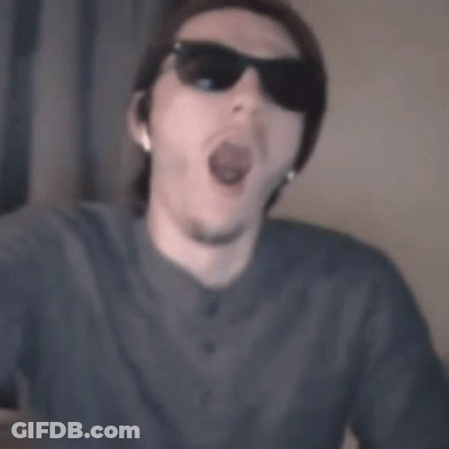 A Man Wearing Sunglasses And A Beanie Is Making A Funny Face GIF