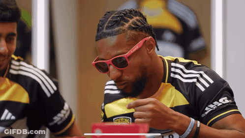 A Man Wearing Sunglasses And A Black And Yellow Shirt With The Number 19 On The Front GIF