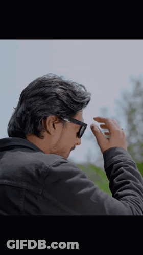 A Man Wearing Sunglasses And A Black Jacket Adjusts His Glasses GIF