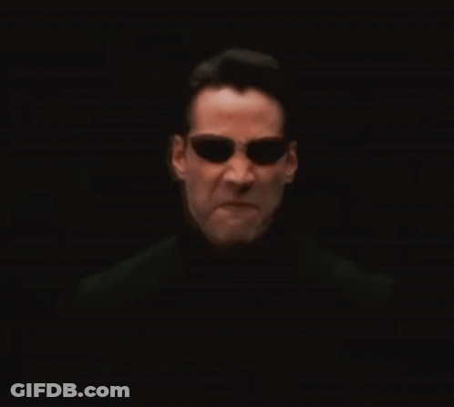 A Man Wearing Sunglasses And A Black Shirt Is Looking At The Camera GIF