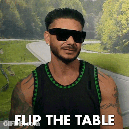 A Man Wearing Sunglasses And A Black Tank Top With The Words Flip The Table On The Bottom GIF