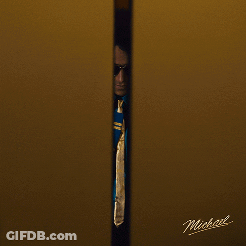 A Man Wearing Sunglasses And A Blue Jacket With The Name Michael On The Bottom Right GIF
