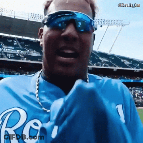 A Man Wearing Sunglasses And A Blue Royals Shirt GIF