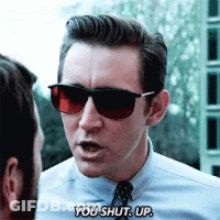 A Man Wearing Sunglasses And A Blue Shirt Is Saying You Shut Up GIF