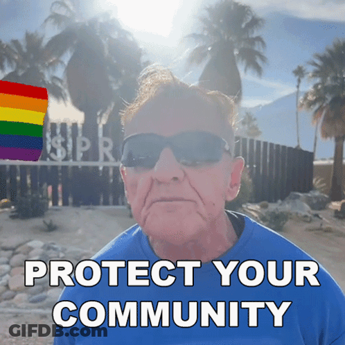 A Man Wearing Sunglasses And A Blue Shirt Stands In Front Of A Sign That Says " Protect Your Community " GIF