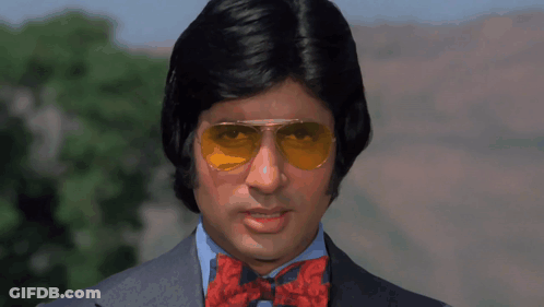 A Man Wearing Sunglasses And A Bow Tie Is Looking At The Camera GIF