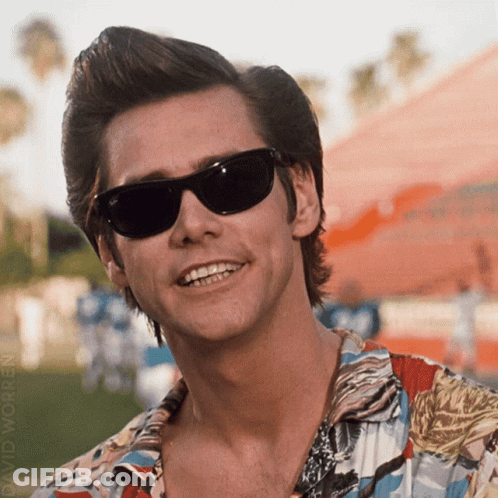 A Man Wearing Sunglasses And A Colorful Shirt Smiles GIF