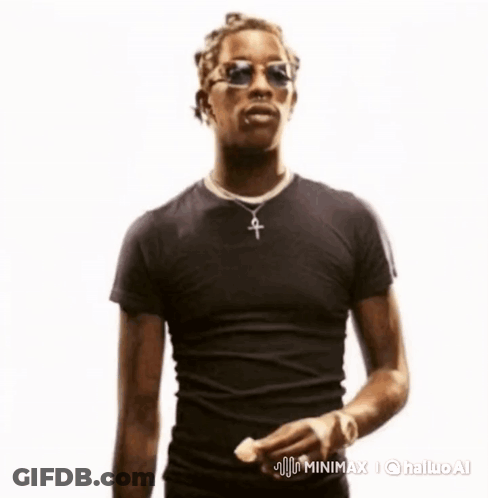 A Man Wearing Sunglasses And A Cross Necklace Is Standing In Front Of A White Background GIF