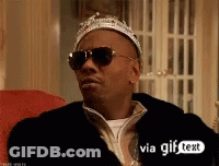 A Man Wearing Sunglasses And A Crown Sitting On A Couch . GIF