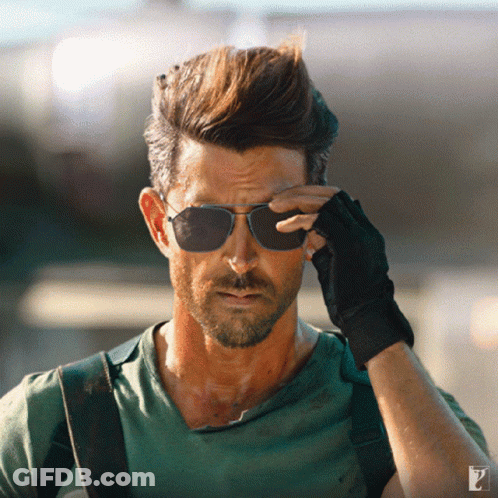 A Man Wearing Sunglasses And A Green Shirt Has The Letter P On The Bottom Right GIF
