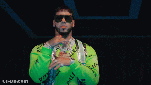A Man Wearing Sunglasses And A Green Sweater With The Word Balenciaga On It GIF