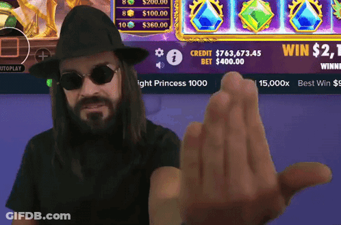 A Man Wearing Sunglasses And A Hat Holds Up His Hand In Front Of A Screen That Says Win $ 2.1 GIF
