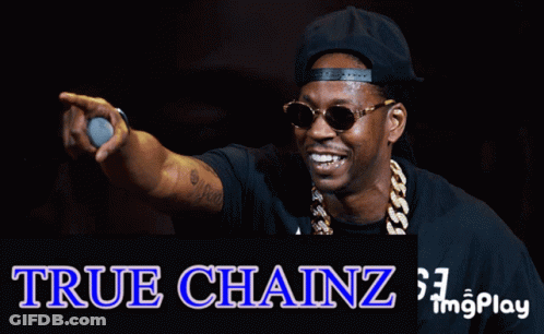 A Man Wearing Sunglasses And A Hat Is Holding A Microphone In Front Of A True Chainz Logo GIF