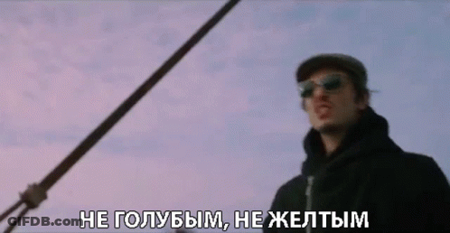 A Man Wearing Sunglasses And A Hat Is Standing In Front Of A Purple Sky GIF