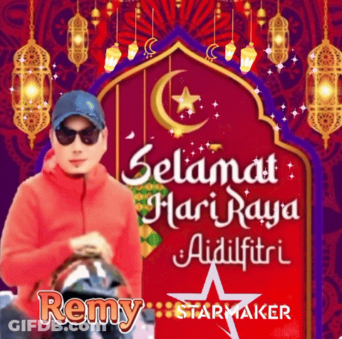 A Man Wearing Sunglasses And A Hat Is Standing In Front Of A Red Sign That Says Selamat Hari Raya Aidilfitri GIF