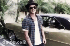 A Man Wearing Sunglasses And A Hat Is Standing Next To A Car GIF