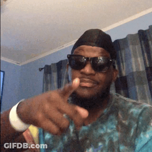 A Man Wearing Sunglasses And A Hat Points His Finger GIF