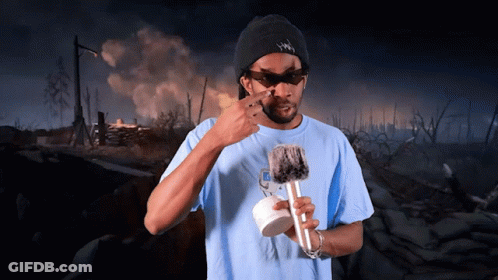 A Man Wearing Sunglasses And A Hat That Says ' Snoop Dogg ' On It Holds A Microphone GIF