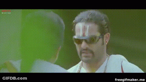 A Man Wearing Sunglasses And A Hat With A T On It GIF