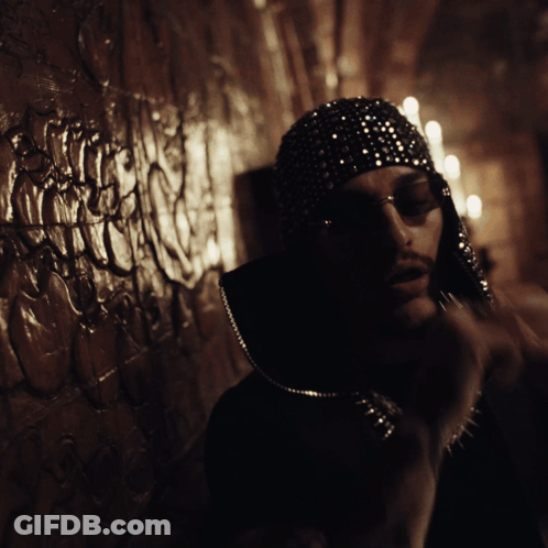 A Man Wearing Sunglasses And A Hat With Sequins On It GIF