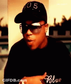 A Man Wearing Sunglasses And A Hat With The Number 0.5 On It GIF