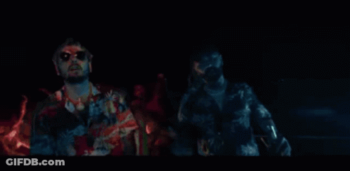 A Man Wearing Sunglasses And A Hawaiian Shirt Is Making A Funny Face With His Hands Outstretched . GIF