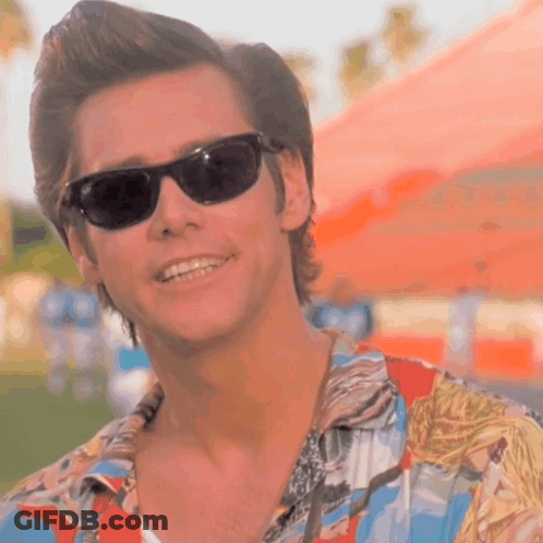 A Man Wearing Sunglasses And A Hawaiian Shirt Smiles GIF