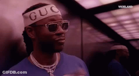 A Man Wearing Sunglasses And A Headband With The Word Guc On It Is Standing In An Elevator . GIF