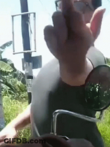 A Man Wearing Sunglasses And A Helmet Giving The Middle Finger GIF