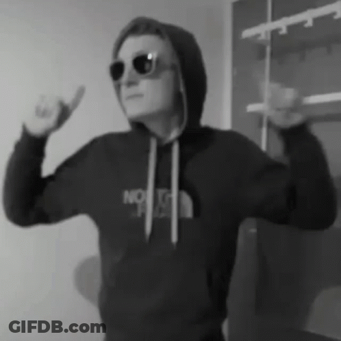 A Man Wearing Sunglasses And A Hoodie Is Making A Funny Face . GIF