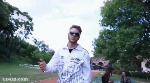 A Man Wearing Sunglasses And A Jacket That Says The City On It GIF