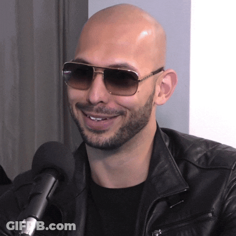 A Man Wearing Sunglasses And A Leather Jacket Is Smiling GIF