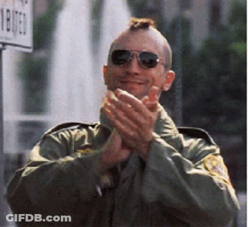 A Man Wearing Sunglasses And A Mohawk Applauds In Front Of A Sign That Says 1807 GIF