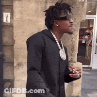 A Man Wearing Sunglasses And A Necklace Is Holding A Cup Of Coffee GIF