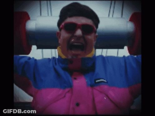 A Man Wearing Sunglasses And A Pink And Blue Jacket GIF