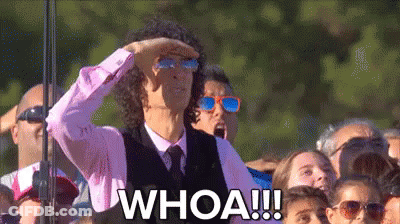 A Man Wearing Sunglasses And A Pink Shirt Is Standing In Front Of A Crowd And Says Whoa . GIF