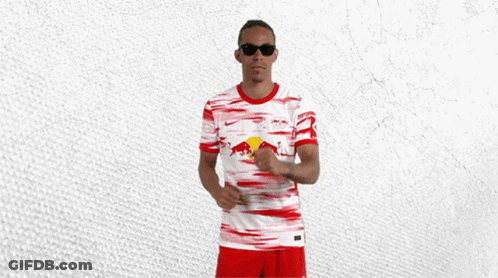 A Man Wearing Sunglasses And A Red And White Jersey With A Red Bull On It GIF